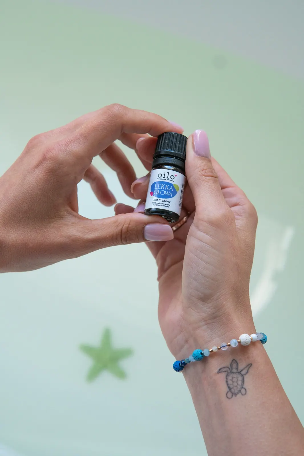 Dłonie trzymające mieszankę olejków eterycznych Oilo Lekka Głowa — 100% olejki, Therapeutic Grade